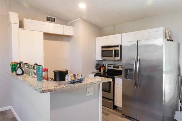 a kitchen with stainless steel appliances granite countertop a refrigerator and a sink