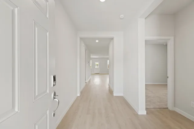 a view of a hallway with wooden floor