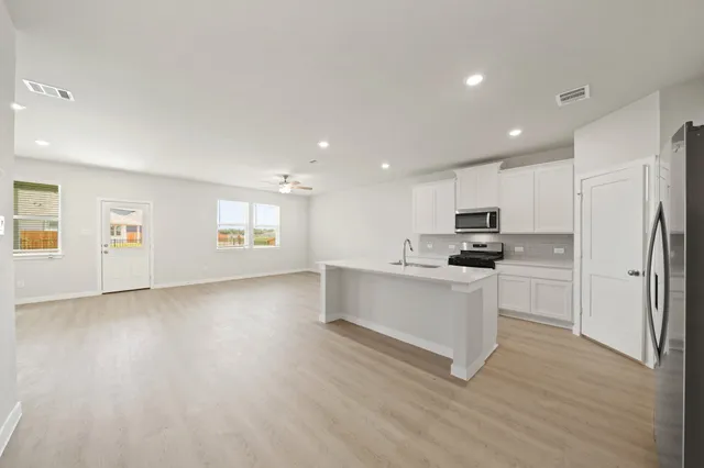 a kitchen with white cabinets and stainless steel appliances