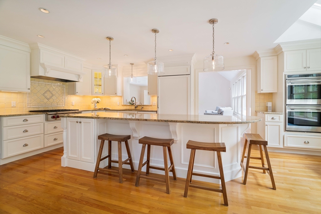 38 Fuller Brook Road Wellesley, MA 02482 - Photo 11 of 42 a kitchen with stainless steel appliances granite countertop a stove a sink refrigerator and white cabinets with wooden floor
