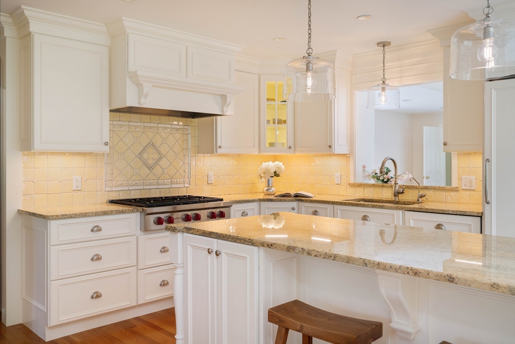 38 Fuller Brook Road Wellesley, MA 02482 - Photo 12 of 42 a kitchen with granite countertop a stove a sink and white cabinets