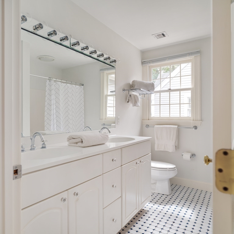 38 Fuller Brook Road Wellesley, MA 02482 - Photo 32 of 42 a bathroom with a sink a toilet a mirror a window and vanity