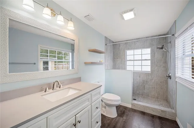 a bathroom with a sink a toilet and shower