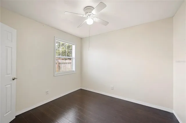 an empty room with a window and a fan