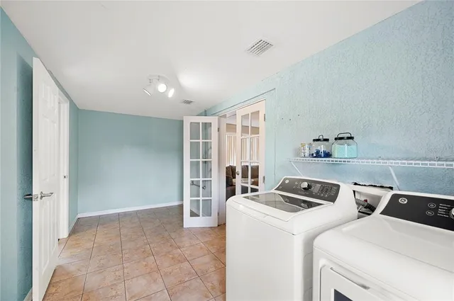a view of washer and dryer with bathroom in the background