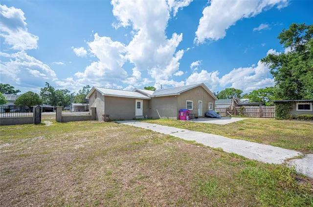 a view of a house with a small yard plants and large tree