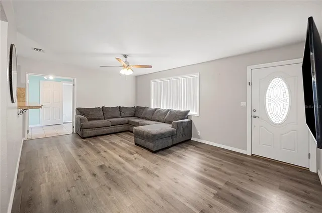 a living room with furniture and a wooden floor