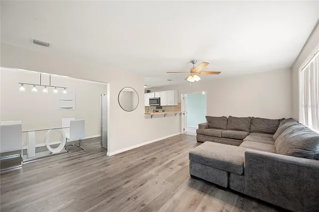a living room with furniture and a wooden floor