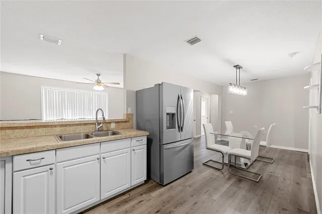 a kitchen with a refrigerator a sink and chairs