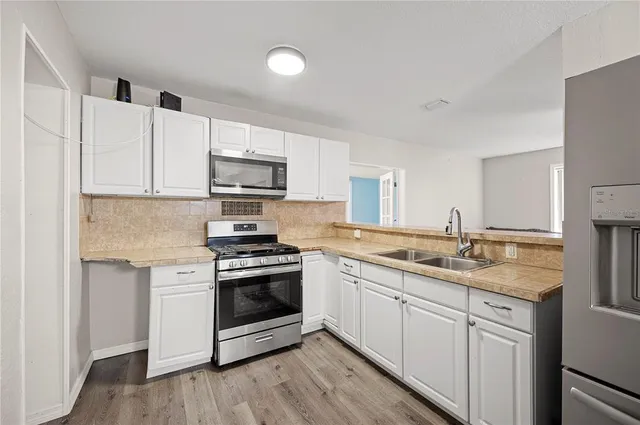 a kitchen with stainless steel appliances granite countertop a sink and a stove