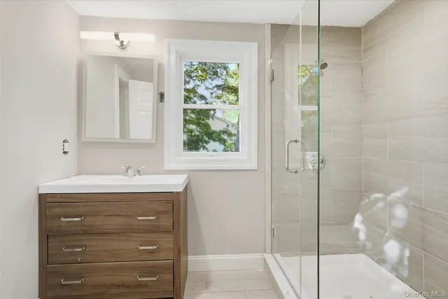 a bathroom with a shower sink and mirror