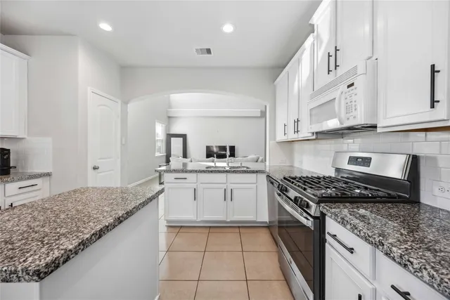 a kitchen with stainless steel appliances granite countertop a sink stove and cabinets