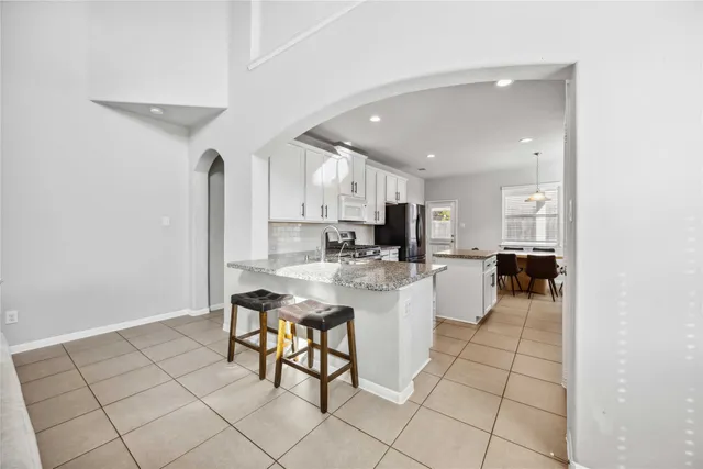 a kitchen with stainless steel appliances kitchen island granite countertop a sink and cabinets