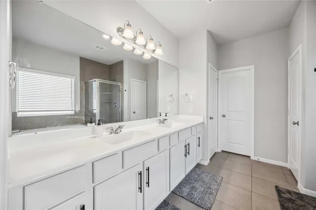 a bathroom with a double vanity sink and a mirror