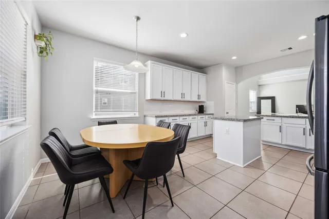 a kitchen with a dining table chairs and white cabinets