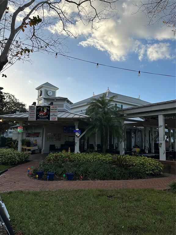 2214 Metropolitan Way, Unit 2210 Orlando, FL 32839 - Photo 9 of 14 a view of a house with a small yard plants and a large tree