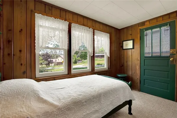 a bedroom with a bed and a large window