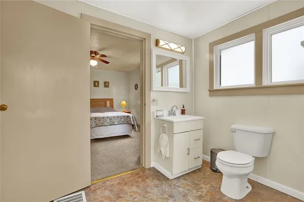 a bathroom with a toilet sink and mirror
