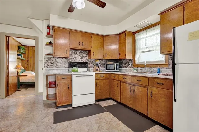 a kitchen with white cabinets and white appliances
