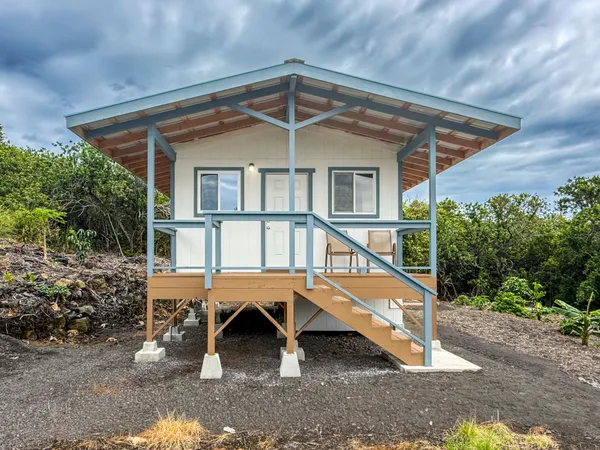 a wooden deck with a table and chairs under an umbrella