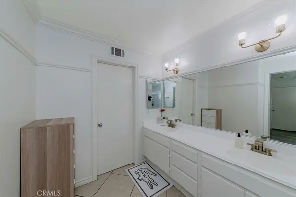 a bathroom with a double vanity sink a mirror and a shower