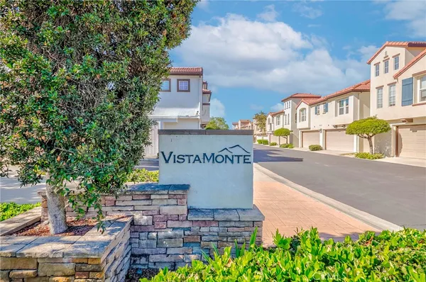 a sign board with buildings in the background