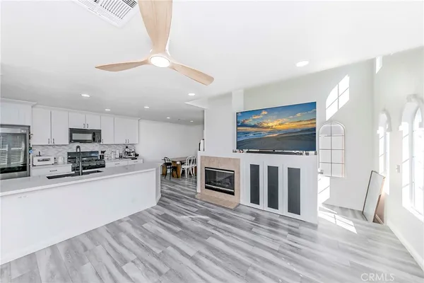 a living room with stainless steel appliances furniture and a flat screen tv