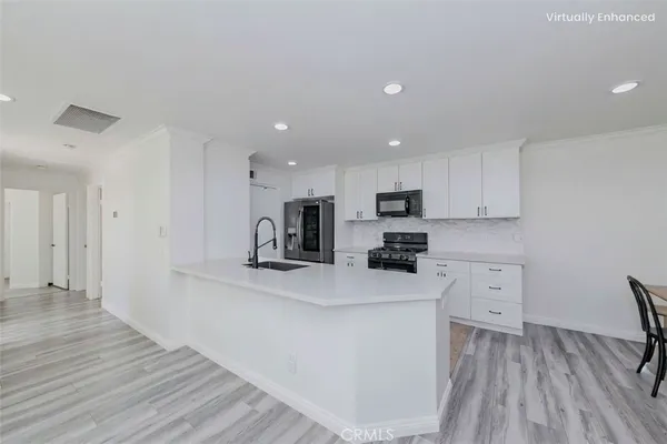a kitchen with white cabinets and stainless steel appliances