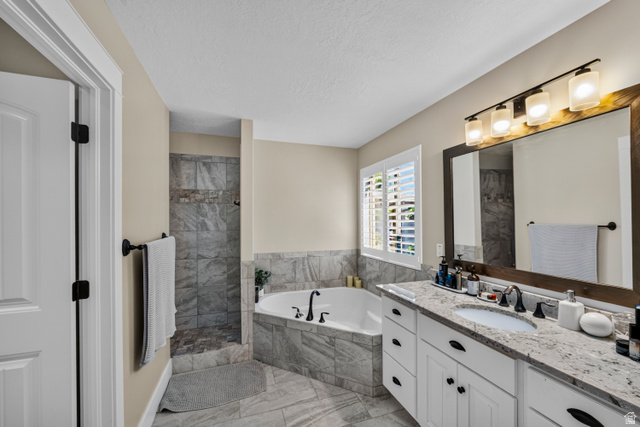 564 Spring Meadow Lane Farmington, UT 84025 - Photo 21 of 31 Spacious bathroom with a walk-in shower, soaking tub, and a vanity featuring a granite-style countertop and dual sinks