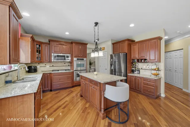 a kitchen with stainless steel appliances granite countertop a sink refrigerator and cabinets