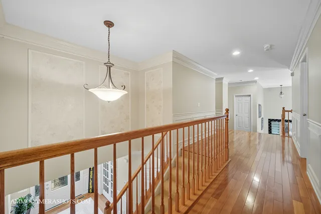 a view of a hallway with wooden floor and a chandelier