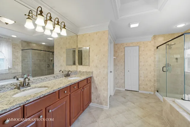 a bathroom with a granite countertop double vanity sink mirror and shower