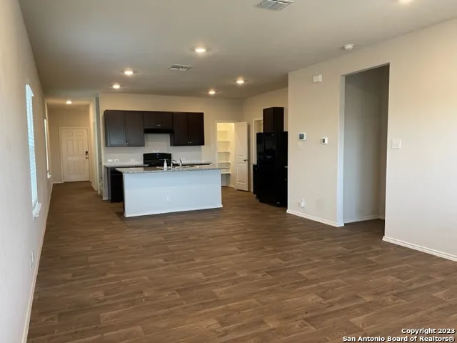 a view of kitchen with kitchen island stainless steel appliances refrigerator stove microwave and cabinets
