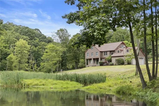 a view of house with garden and tall trees