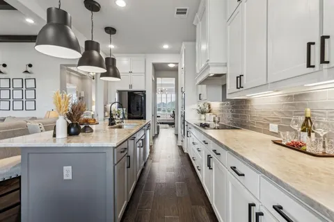 a kitchen with stainless steel appliances granite countertop a sink a stove and a wooden floors