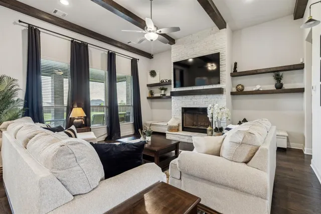 a living room with furniture a flat screen tv and a fireplace