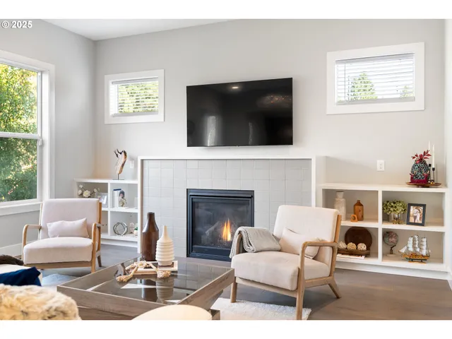a living room with furniture a flat screen tv and a fireplace