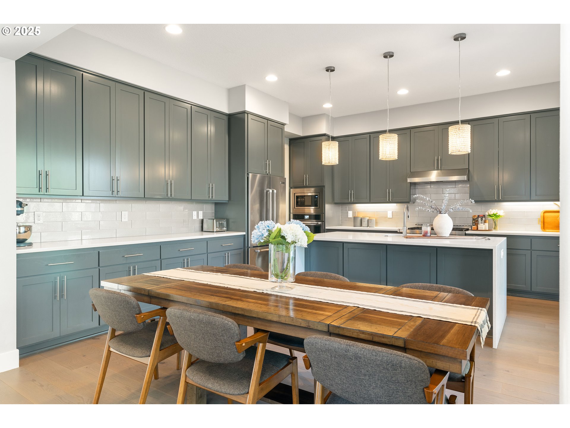 10805 Northwest Cornell Road Portland, OR 97229 - Photo 10 of 39 a kitchen with a dining table chairs and refrigerator