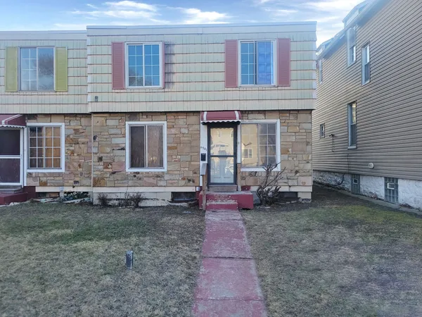 a view of a house with backyard and chairs