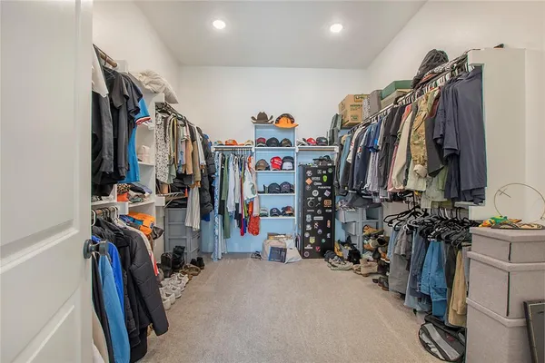 a view of walk in closet with clothes