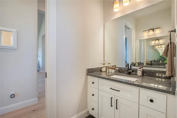 a bathroom with a granite countertop sink and a mirror