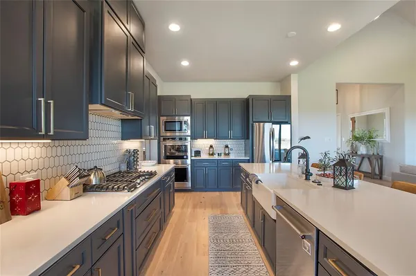 a kitchen with stainless steel appliances a sink stove and cabinets
