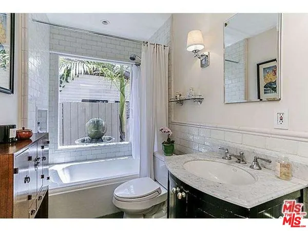 a bathroom with a sink vanity mirror and toilet