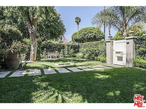 a view of a chairs and table in the back yard of a house