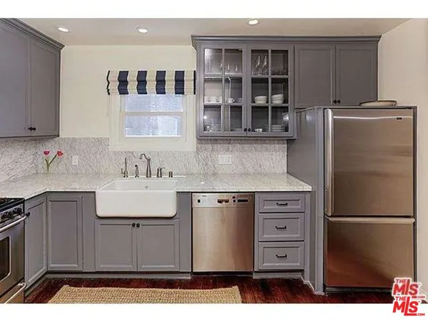 a kitchen with stainless steel appliances granite countertop a refrigerator and a sink