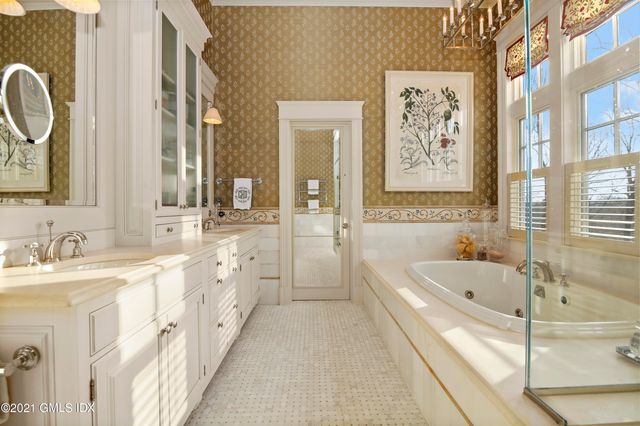 a spacious bathroom with sinks mirror and a bathtub