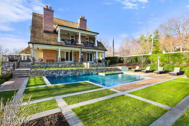 a front view of a house with swimming pool having outdoor seating
