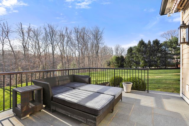 a view of a roof deck with couches and wooden fence