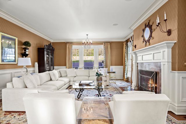a living room with furniture a fireplace and a large window