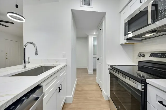 a kitchen with a sink and stainless steel appliances